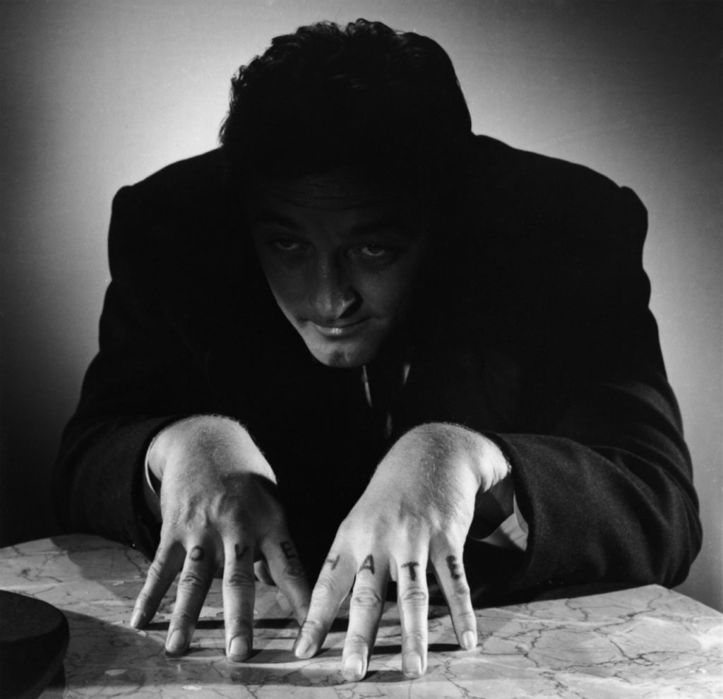 Publicity photo from THE NIGHT OF THE HUNTER featuring Robert Mitchum and his knuckle tattoos.